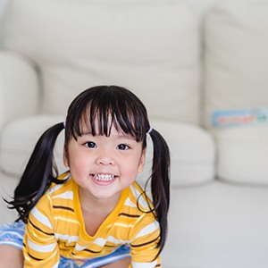 Portrait of smiling toddler wearing a yellow striped t-shirt