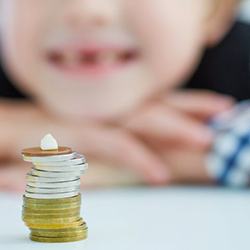 a stack of coins and a baby tooth