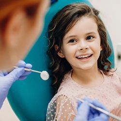 a child patient smiling while undergoing a dental checkup