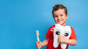 Child holding a stuffed tooth and toothbrush